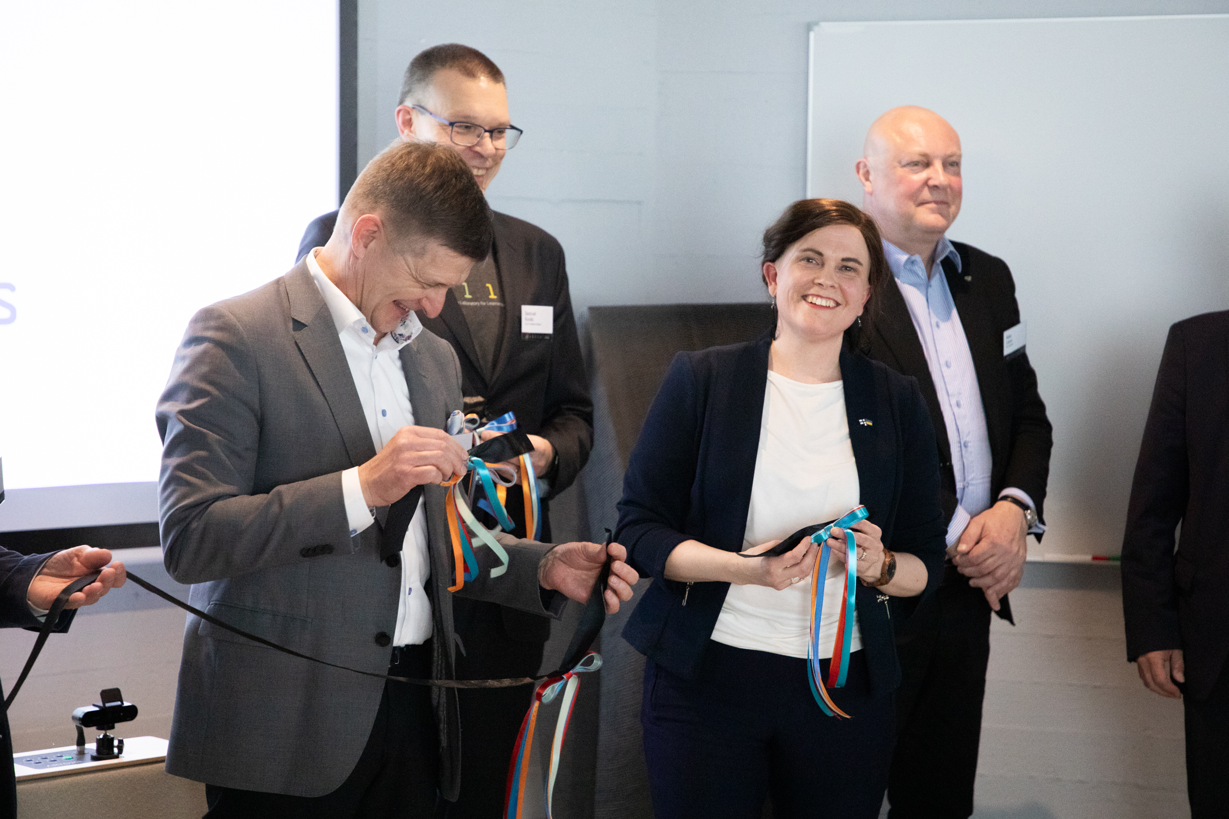 People standing in a group holding ribbons