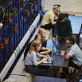 Group of people sitting and standing around table with laptops open