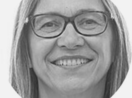 Portrait of a smiling woman with glasses.