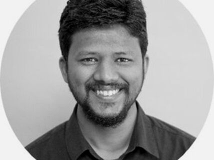 Portrait of a smiling, dark-haired man with a beard.