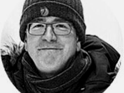 Portrait of a man with glasses and a beanie.