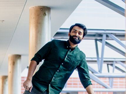 Smiling man leaning on one arm on a railing