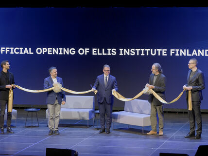 Five people holding a cut gold ribbon with text in background: OFFICIAL OPENING OF ELLIS INSTITUTE FINLAND