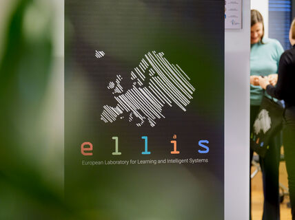 Roll-up with ELLIS logo in the front and two persons standing on the background.