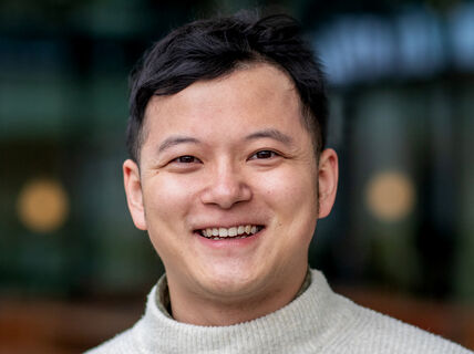 Smiling person wearing a light-colored sweater