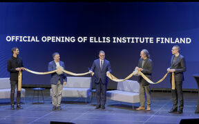 Five people holding a cut gold ribbon with text in background: OFFICIAL OPENING OF ELLIS INSTITUTE FINLAND