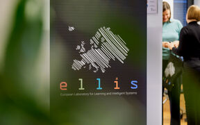 Roll-up with ELLIS logo in the front and two persons standing on the background.