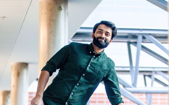 Smiling man leaning on one arm on a railing