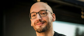 Photo of man with glasses and a black shirt
