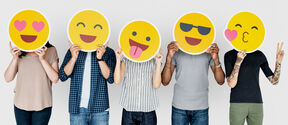 Five people holding different emoji over their faces
