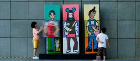 Two children playing with a colorful character combination installation (blocks that can be flipped)