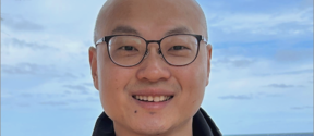 Person wearing glasses against a sea background