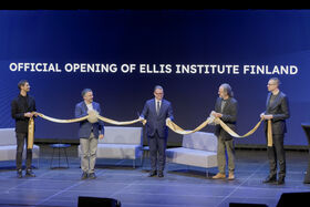Five people holding a cut gold ribbon with text in background: OFFICIAL OPENING OF ELLIS INSTITUTE FINLAND