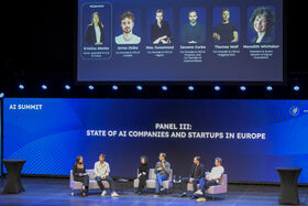 Six people seated on stage with their pictures projected overhead. Text in background: PANEL III: State of AI companies and startups in Europe