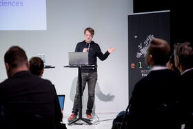 Man stands at podium with laptop