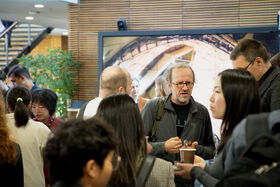 Crowd of people standing and talking in a lobby