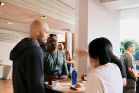Blurry shot of people standing and having a coffee break