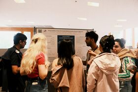 People standing in front of a scientific poster