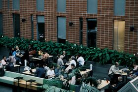 People sitting around tables in a building atrium