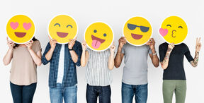 Five people holding different emoji over their faces