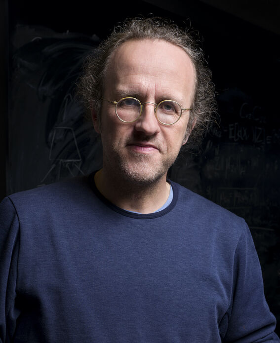 Person wearing round spectacles against a black background