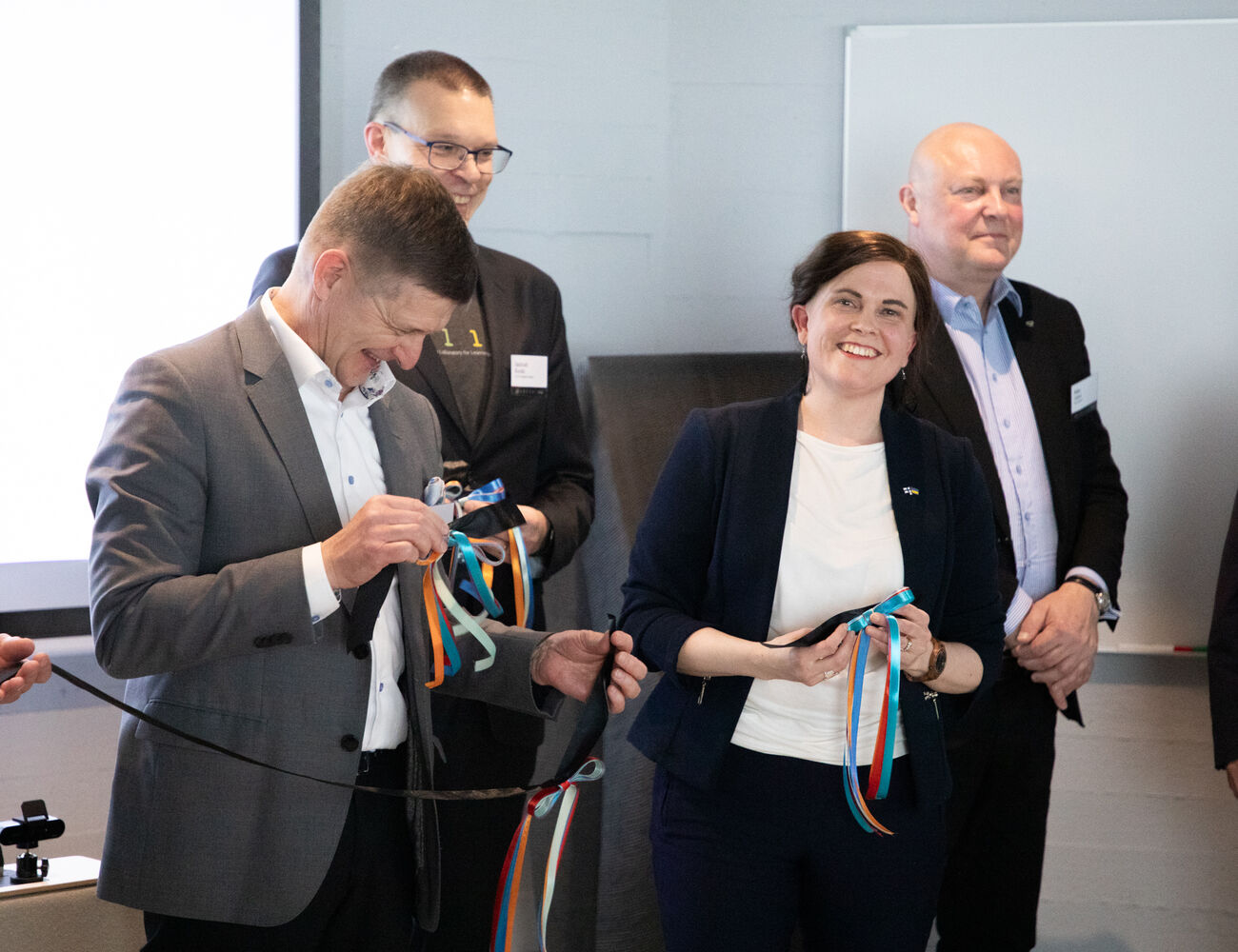 People standing in a group holding ribbons