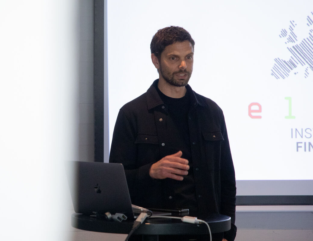 Man speaking in front of a screen